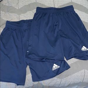 Two pairs of kids Adidas running shorts.